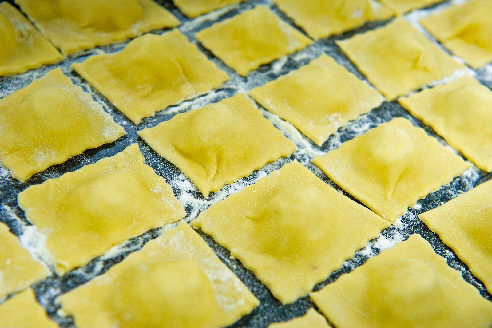 Ravioli freschi appena formati sul piano infarinato