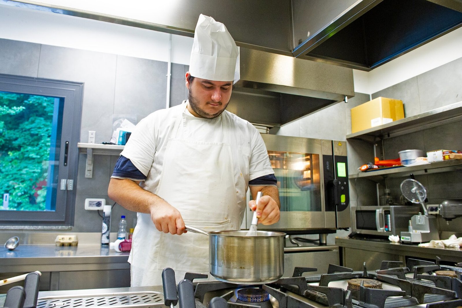 Lo chef al lavoro con le pentole ai fornelli